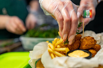 woman chef cooking Chicken Nuggets with French Fries and sauce on kitchen