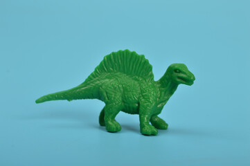 Toy spinosaurus dinosaurs isolated on a blue background