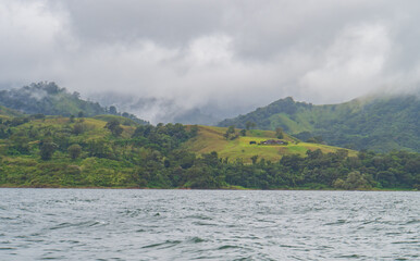 mist and clouds over the lush tropical landscape along Lake Arenal in Costa Rica
