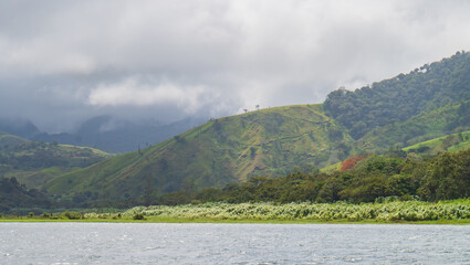 mist and clouds over the lush tropical landscape along Lake Arenal in Costa Rica
