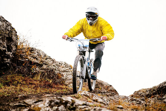 man rider in yellow jacket riding mountain trail