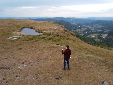 Pessoa tomando vinho em uma paisagem na serra catarinense