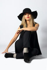 Young woman with hat in studio posing on white background