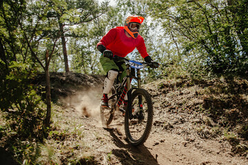 athlete rider downhill race dusty trail in forest