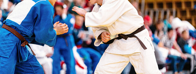 fight of two judoka athletes in judo competition - Powered by Adobe