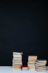 many books large stacks on the table in the library on a black background