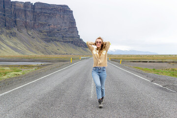 Road on Iceland, blond woman walking, amazing view, summer time