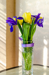 flowers as a gift to a woman yellow tulips and blue irises in the sunlight