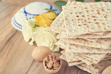 Passover celebration concept. Matzah, red kosher and walnut. Traditional ritual Jewish bread...