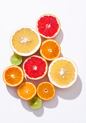 Fresh citrus fruit: oranges, red blood oranges(tarocco), pomelo, lime om the white background , sunlight, top view