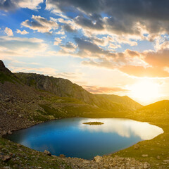 small lake in green mountain valley at the sunset