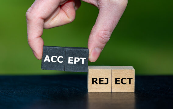 Hand picks wooden cubes with the word accept instead of cubes with the word reject.
