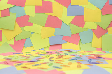 Multicolored paper clips on multicolored paper Sticky Notes