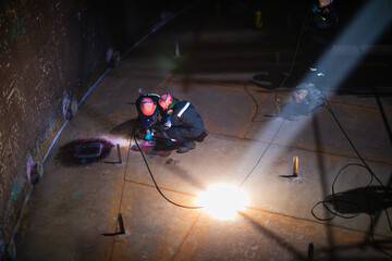 Male worker inspection vacuum test bottom plate tank petrochemical steel weld leak spot light...