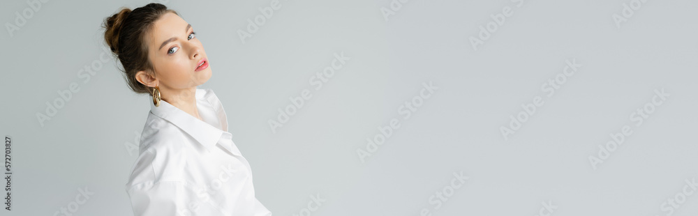 Wall mural portrait of trendy woman with natural makeup posing in white oversize shirt isolated on grey, banner