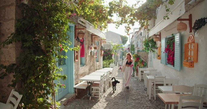a cozy street in turkey in the city of alachaty, a woman with a dog walking in the summer