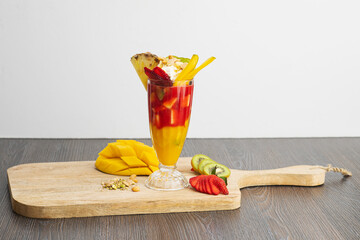 Fruit Cocktail cup on a table, Tropical fruits cocktail with strawberry and mango 
