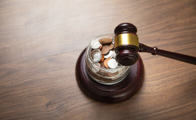 Stack of coins with judge gavel.