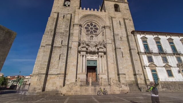 Porto Cathedral or Se Catedral do Porto timelapse hyperlapse front view with blue sky at sunny day. Romanesque and Gothic architecture.