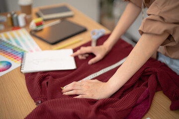 Obraz premium Tailor woman working in tailor shop Stylish Fashion designer tailor in workshop studio designing new collection Dressmaking and Creative.fashion collection.