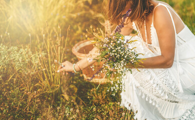 Woman collects beautiful spring flowers in a summer day.