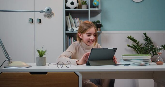 Good-looking happy laughing student girl with tablet pc over home room background. Education, technology and school concept