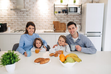Happy family having breakfast at home. Having healthy breakfast on modern stylish kitchen