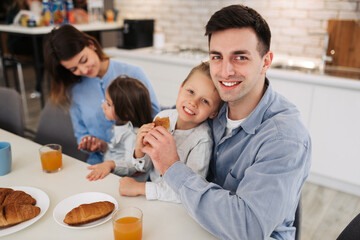 Portrait of happy father and son having breakfast together at dining table