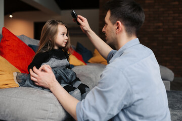 The father helps his daughter to brush the hair. Before going to work and at school, daughter and father spend nice moments