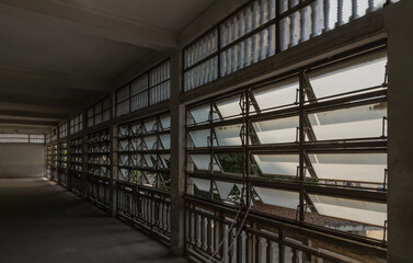 Ancient steel awning windows open for bright light streaming through the corridor interior the ancient building. Manual hand rotating glass windows.