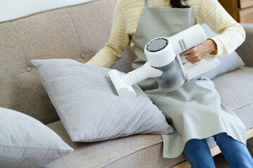 House wife with rechargeable vacuum cleaner cleaning at home