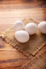 Many white chicken eggs on rustic wooden table. Very popular nutritious and economic food product.