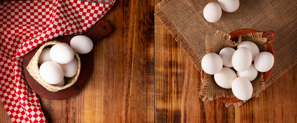 Many white chicken eggs on rustic wooden table. Very popular nutritious and economic food...