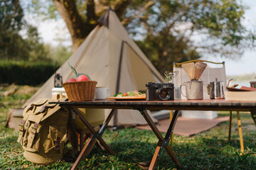 Outdoor Camping Table set with nature beside tent campsite. Travel and camping concept © mojo_cp