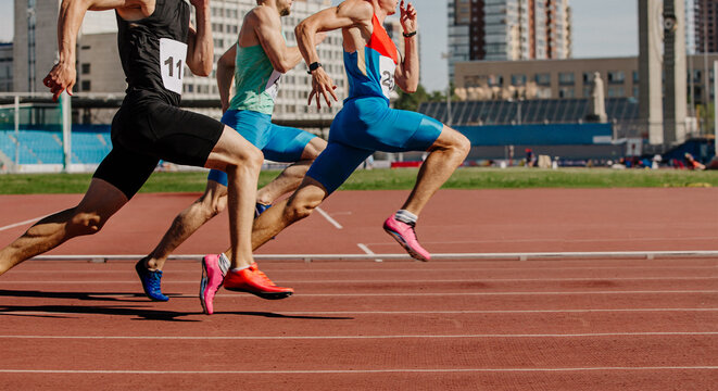 men sprinters run on track stadium in athletics competition