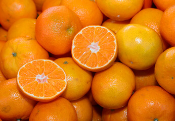 orange clementines or tangerines and some cut in half for sale in the greengrocer
