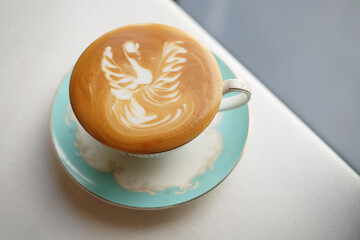 Cafe latte with latte art place on white ceramic background