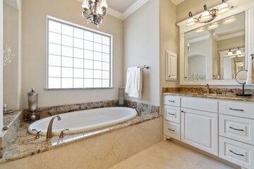 A large master bathroom with white accenting 