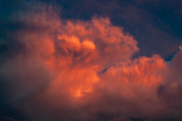 Fototapeta na wymiar The crimson sunset illuminates the rain clouds in a bloody color