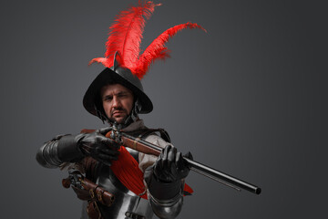 Obraz premium Studio shot of rifleman dressed in plate armor and helmet holding rifle.