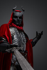 Obraz premium Portrait of evil knight with black mask pointing his sword to camera.