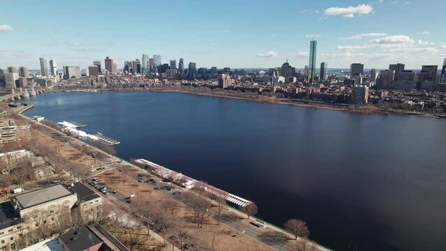 Drone and aerial establishing moving shot towards high-rise skyscrapers, tall apartments, and business developments in downtown Boston, Massachusetts on a sunny, winter day near the Charles River