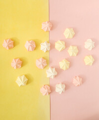 pink , white, yellow merengues candy in a pink and yellow background