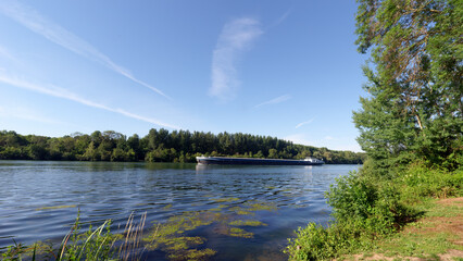 Barge on Seine river along  the Rougeau forest 
