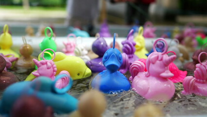 Plastic ducks floating at pool amusement park. fishing game at funfair festival party
