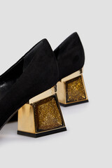 Square heels women's shoes isolated on white background. Female classic heels in suede leather. Black Gold color. Mock up, template. Behind view