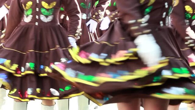 close up of a group of female mexican dancers wearing a traditional mexican dress, weaving from one side to another the dress during a typical dance in carnival