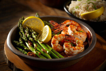 A bowl of with grilled shrimp, served with a side of steamed asparagus and two lemon wedge, generative ai