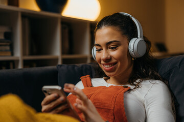 Young caucasian woman relaxes at home with music - obrazy, fototapety, plakaty