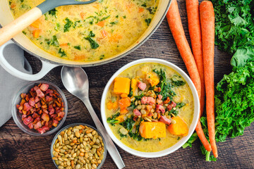 Sweet Potato Chowder in a Bowl and Dutch Oven with Garnishes: Creamy vegetable soup topped with fried pancetta and roasted pepitas